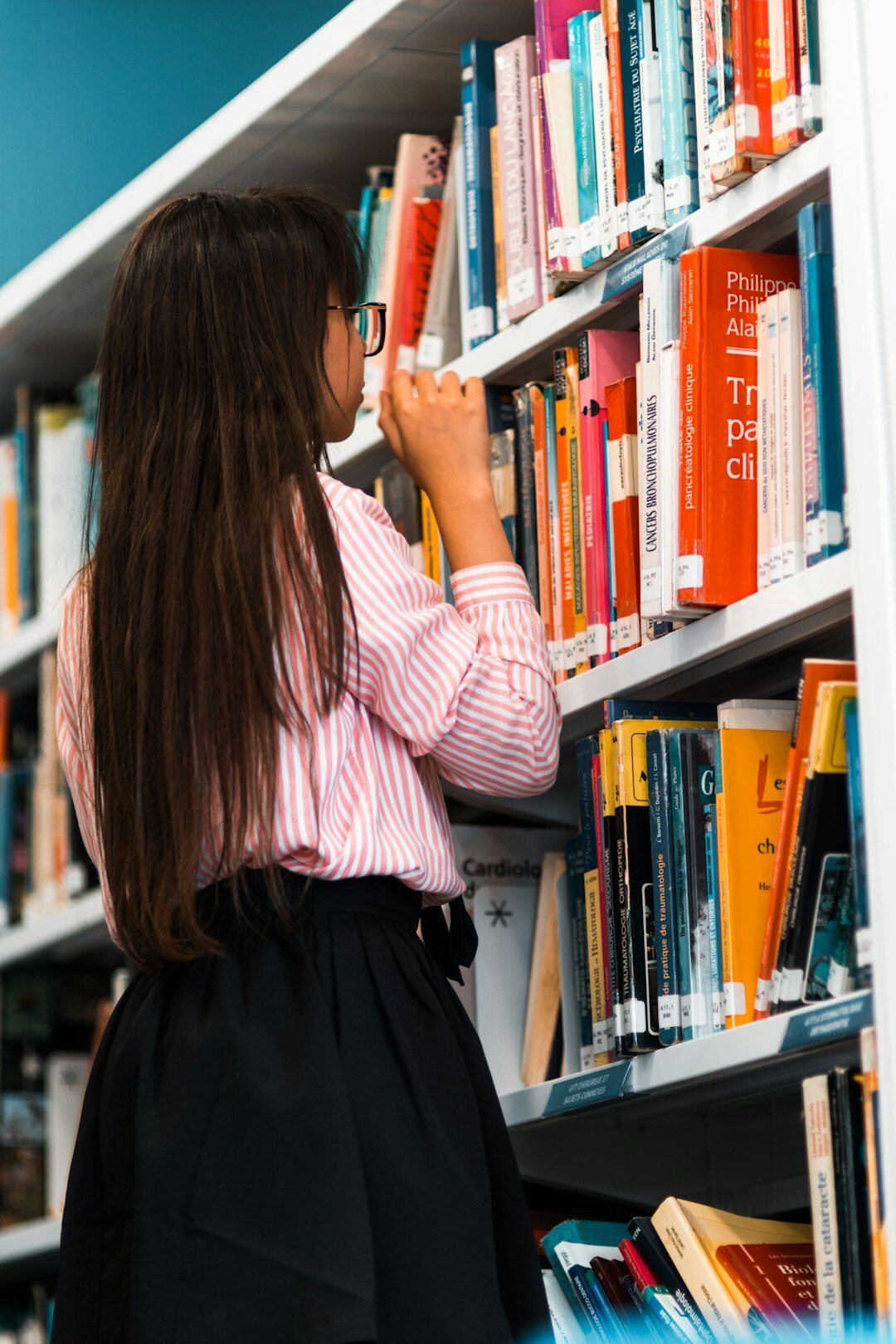 Young woman reading a book in a library
